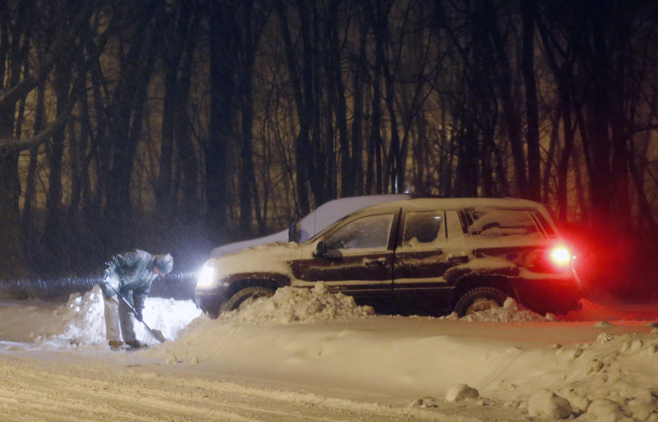 A man clears a path in his driveway in Norwell, Mass., Friday, Jan. 3, 2014. A winter storm slammed into the U.S. Northeast with howling winds and frigid cold, dumping nearly 2 feet (60 centimeters) of snow in some parts and whipping up blizzard-like conditions Friday. (AP Photo/Michael Dwyer)