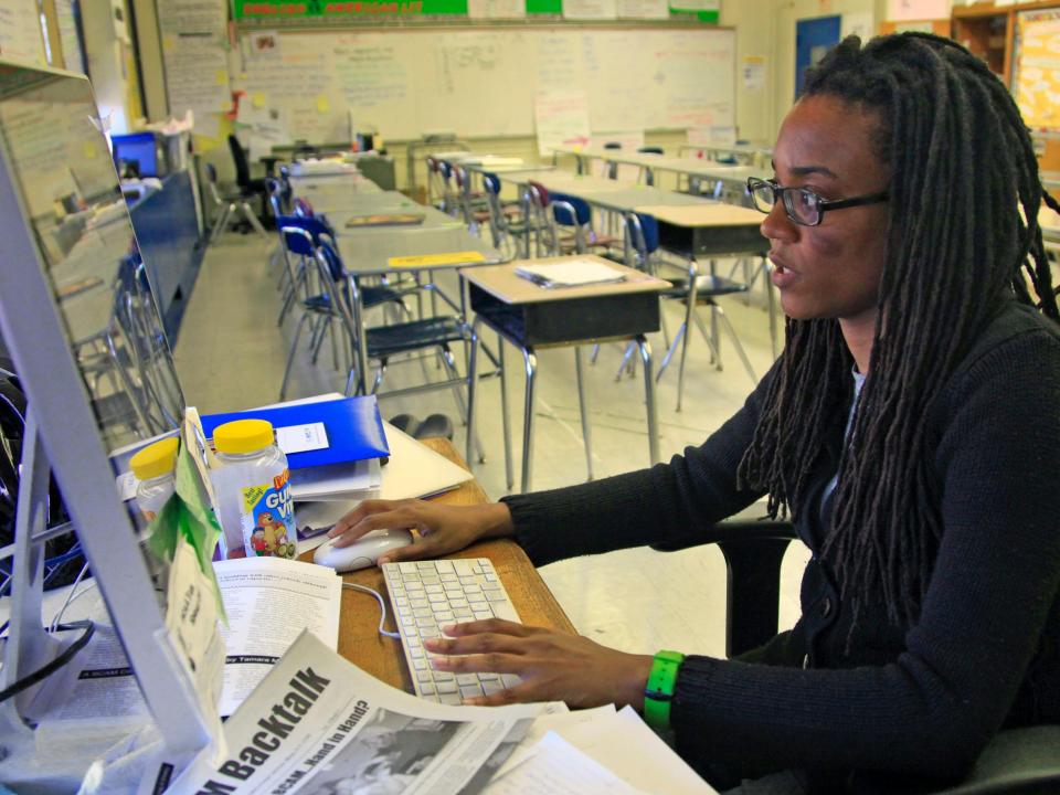 A teacher works at her classroom computer in 2012
