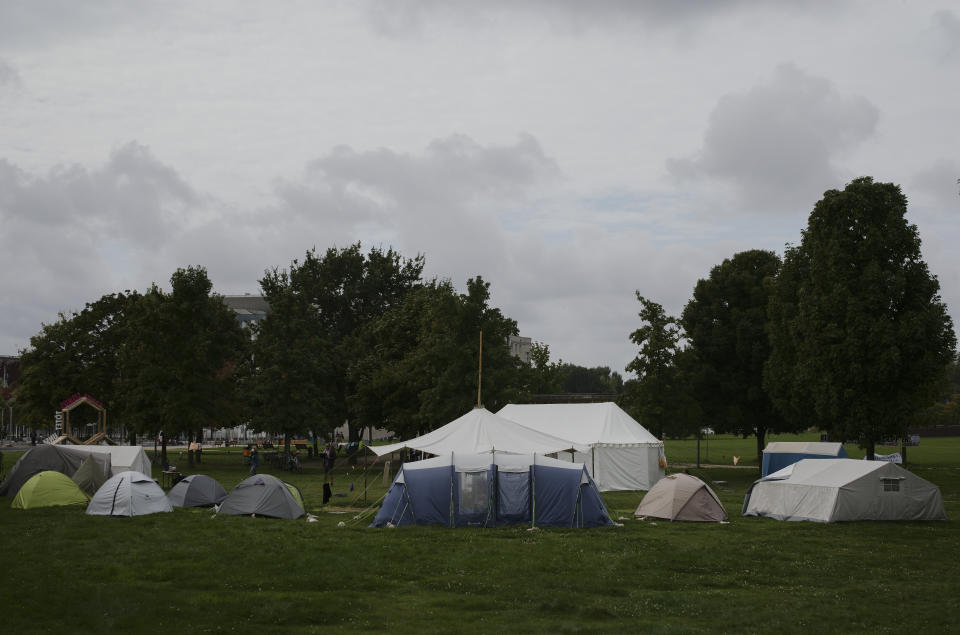 A small camp of climate activists is set up near the chancellary, background behind the trees, in Berlin, Wednesday, Sept. 22, 2021. In the camp climate activists on a hunger strike and hope to pressure candidates for chancellor of Germany into meeting them for a debate about the climate crisis ahead Sunday's general election. For the first time in Germany's history, climate change is a central issue of an election campaign, overwhelmingly so for the young generation.(AP Photo/Markus Schreiber)