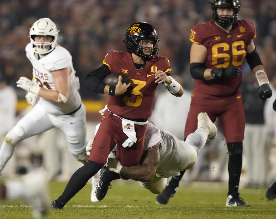 Iowa State quarterback Rocco Becht (3) is sacked by Texas defensive lineman Byron Murphy, bottom center, during the first half of an NCAA college football game, Saturday, Nov. 18, 2023, in Ames, Iowa. (AP Photo/Matthew Putney)