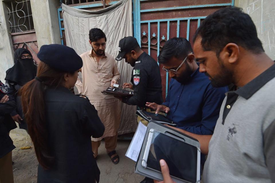 Pakistani police officials check the documents of people during search operation for undocumented immigrants in Karachi (EPA)