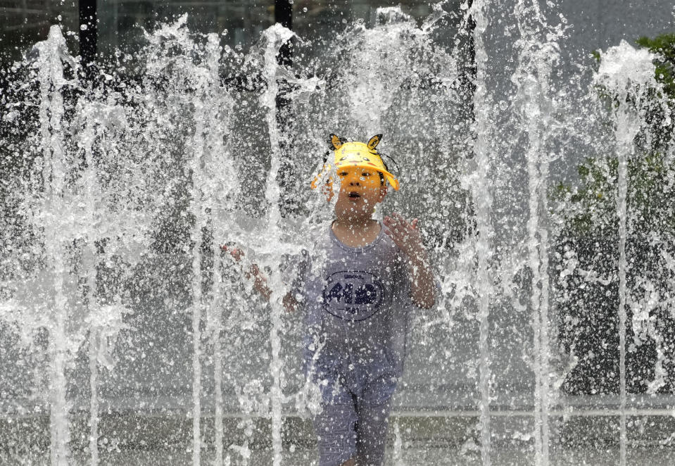 FILE - A boy cools off in a public fountain in Seoul, South Korea, Monday, June 19, 2023. A heat wave warning was issued in Seoul as temperatures soared above 34 degrees Celsius (93 degrees Fahrenheit) Monday. As the heat breaks records, weakening and sickening people, it’s worth remembering that dire heat waves have inspired effective efforts to prevent heat illness. (AP Photo/Ahn Young-joon, File)