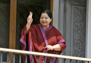 FILE PHOTO - J. Jayalalithaa, leader of Anna Dravida Munetra Khazhgam (AIADMK) flashes a victory sign toward her supporters from the balcony of her residence after winning state election in the southern Indian city of Chennai May 13, 2011. REUTERS/Babu/File Photo