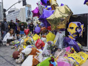 Fans gather at a memorial for the late Kobe Bryant in front of Staples Center in Los Angeles Sunday, Feb. 2, 2020. Bryant, the 18-time NBA All-Star who won five championships and became one of the greatest basketball players of his generation during a 20-year career with the Lakers, died in a helicopter crash Sunday, Jan. 26. (AP Photo/Damian Dovarganes)