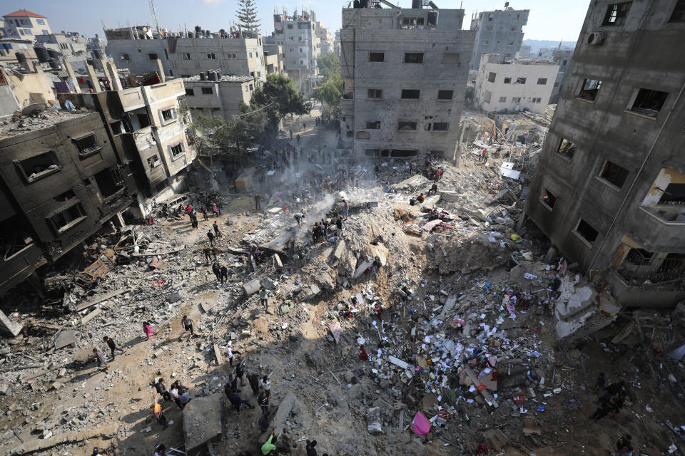 Palestinians look at destruction after an Israeli strike on the Gaza Strip in Nusseirat refugee camp, central Gaza Strip, Friday, Nov. 17, 2023. (AP Photo/Marwan Saleh)