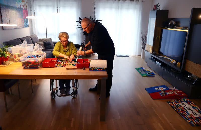 Rita Ebel (L), nicknamed "Lego grandma", and her husband Wolfgang build a wheelchair ramp from donated Lego bricks in the living room of their flat in Hanau