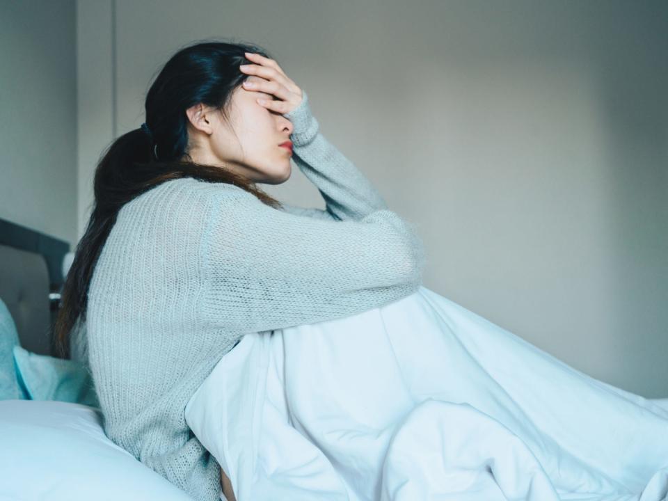 Woman distressed sitting in bed.