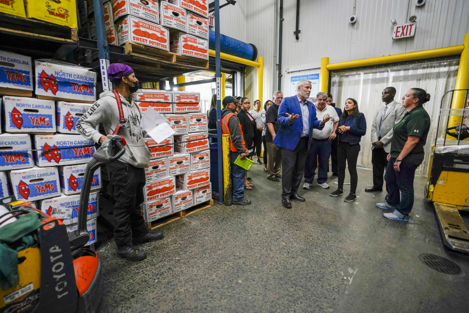 Rep. Alexandria Ocasio-Cortez, D-N.Y., third from right tours the Hunts Point Produce Market with Teamsters Local 202 President Danny Kane, left, and President of S, Katzman Produce Stephen Katzman, second from left, Thursday, July 7, 2022, in the Bronx borough of New York. As she seeks a third term this year and navigates the implications of being celebrity in her own right, she's determined to avoid any suggestion that she is losing touch with her constituents. (AP Photo/Mary Altaffer)