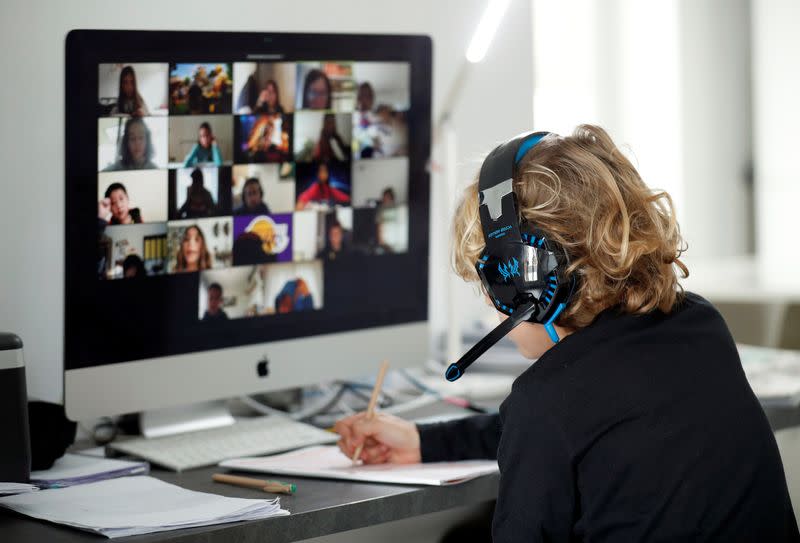 A student takes classes online with his companions using the Zoom APP at home