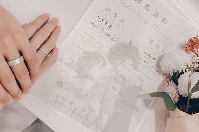 小倆口曬出背景印有合照的結婚書約，雙手相握的畫面閃瞎眾人。（圖／翻攝自粿粿臉書）