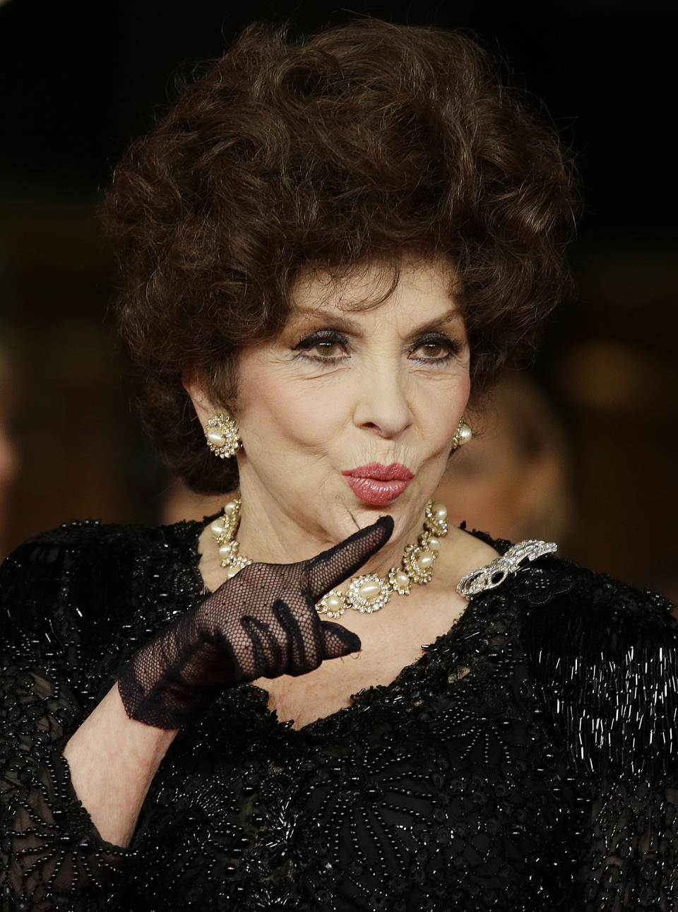 FILE - Actress Gina Lollobrigida poses for photographers as she arrives for the screening of a documentary on Miss Italy during the 7th edition of the Rome International Film Festival in Rome, Friday, Nov. 16, 2012. Lollobrigida, who embodied the Italian stereotype of Mediterranean beauty and was dubbed "the most beautiful woman in the world" after the title of one her movies, has died in Rome at age 95. (AP Photo/Gregorio Borgia, File)