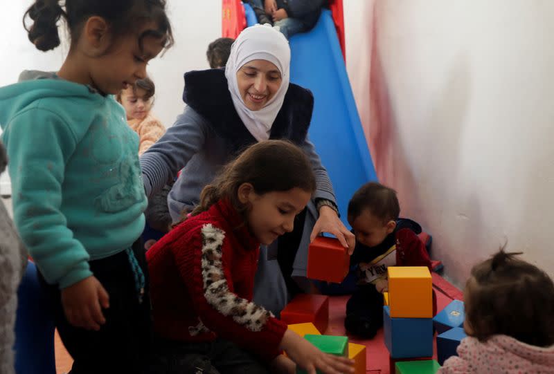 Safaa Kamel, a teacher, plays with children at a school in the northern Syrian town of Afrin