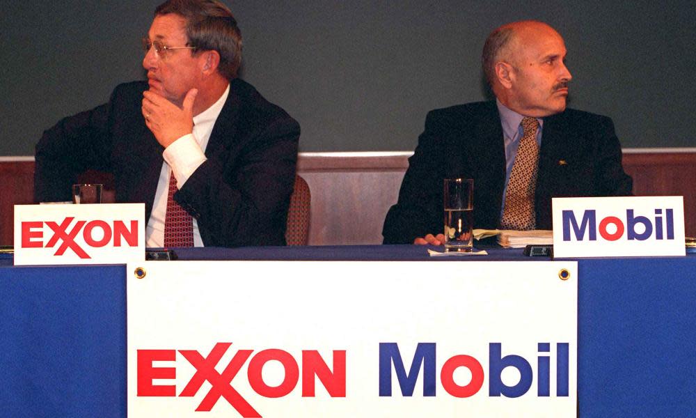 Lee Raymond, chairman of Exxon Corp., left, and Lucio Noto, chairman of Mobil Corp., look in opposite directions during the news conference to announce the merger of their companies Tuesday, Dec. 1, 1998, in New York.