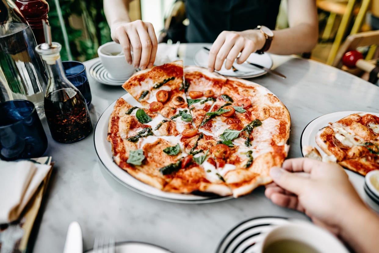 a photo of two people sharing a pizza together at a restaurant