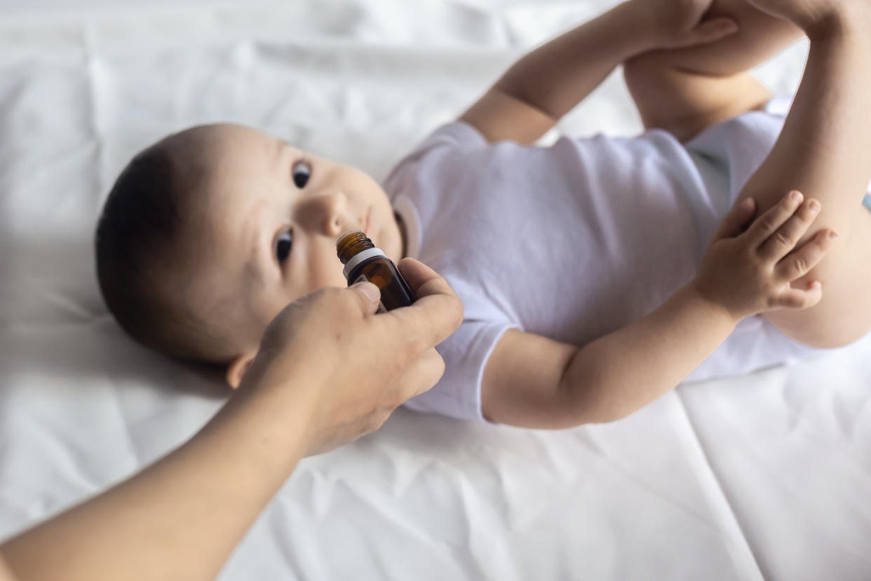 A doctor gives newborn baby rotavirus vaccine. Child immunization with little drop in clinic. Baby boy gets medicine from a little bottle. Immunization, Vaccination, Health concept.