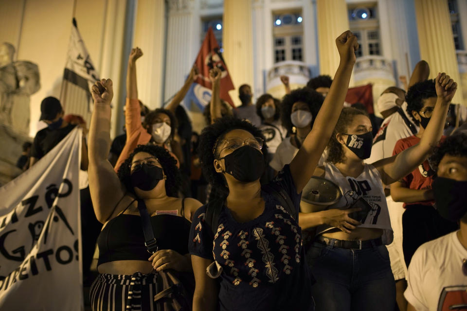 Demonstrators shout slogans during a protest against the government's response in combating COVID-19 and also asking for the extension of emergency aid by the federal government amid the pandemic in Rio de Janeiro, Brazil, Thursday, Feb. 18, 2021. (AP Photo/Silvia Izquierdo)
