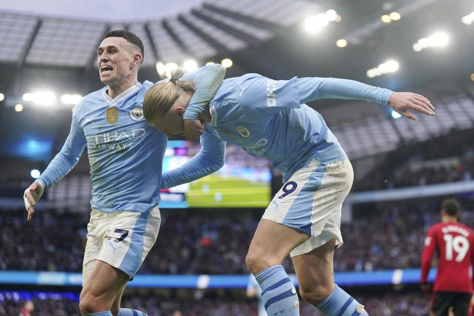 Manchester City's Erling Haaland, right, celebrates with teammate Phil Foden, after scoring his side's third goal during the English Premier League soccer match between Manchester City and Manchester United at the Etihad Stadium in Manchester, England, Sunday, March 3, 2024. (Mike Egerton/PA via AP)