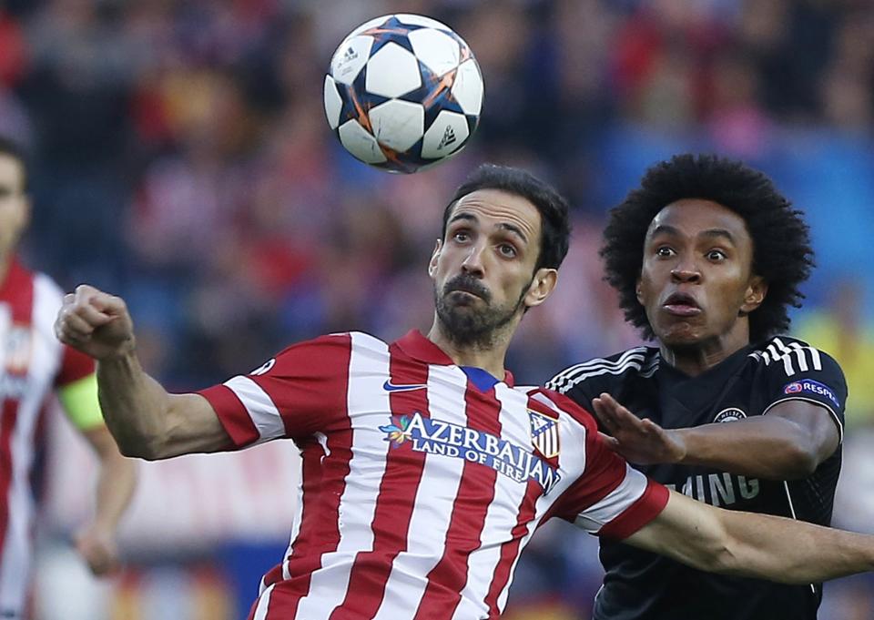 Atletico's Juanfran, left, clears the ball from Chelsea's Willian during the Champions League semifinal first leg soccer match between Atletico Madrid and Chelsea at the Vicente Calderon stadium in Madrid, Spain, Tuesday, April 22, 2014. (AP Photo/Andres Kudacki)