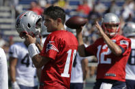 <p>New England Patriots quarterback Jimmy Garoppolo, left, removes his helmet as quarterback Tom Brady, right, winds up for a pass during an NFL football training camp practice, July 28, 2016, in Foxborough, Mass. (Photo: Steven Senne/AP)</p>