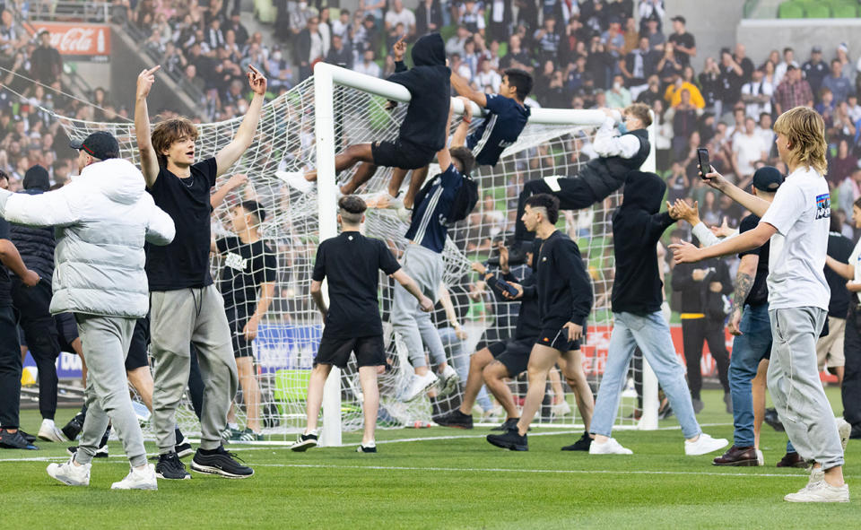 Fans, pictured here invading the pitch and swinging off the goal posts during Melbourne Victory's clash with Melbourne City.