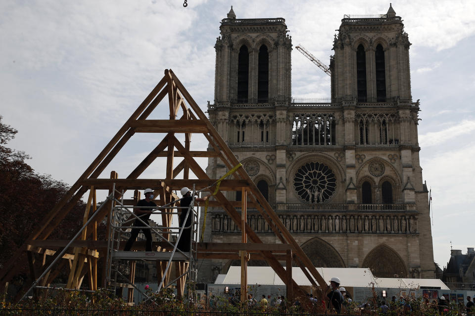 Carpenters put the skills of their Medieval colleagues on show on the plaza in front of Notre Dame Cathedral in Paris, France, Saturday, Sept. 19, 2020, the day honoring European heritage, by reproducing for the public a section of the elaborate carpentry used when the edifice was built. The elaborate wooden beams went up in flames in a devastating April 2019 fire that also toppled the spire of the cathedral, now being renovated. (AP Photo/Francois Mori)