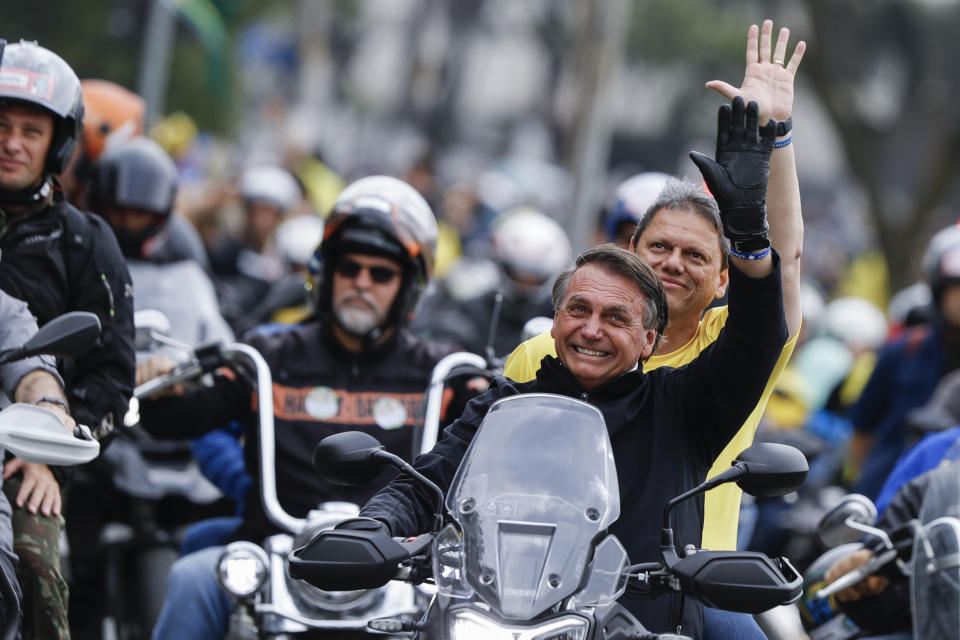 Brazil's President Jair Bolsonaro who is running for re-election, leads a caravan of motorcycle enthusiasts with Sao Paulo governor's candidate Tarcisio de Freitas, riding on the backseat, during a campaign event in Sao Paulo, Brazil, Saturday, October 1, 2022. Brazilians head to the polls to elect a president on Oct. 2. (AP Photo/Marcelo Chello)