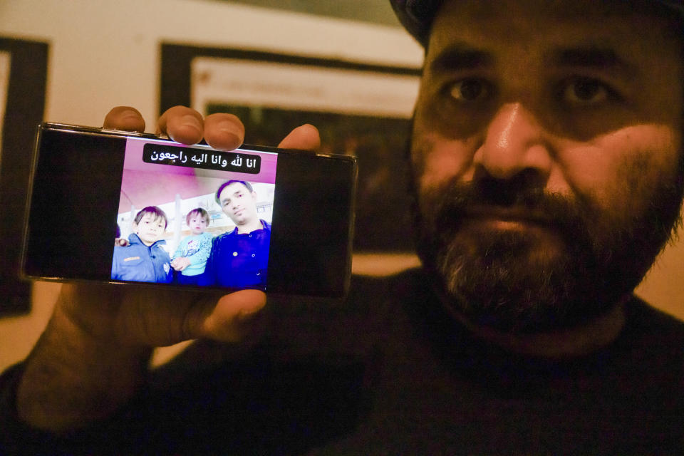 Gul Aqa Jamshidi from Herat, Afghanistan, shows his phone in Crotone, southern Italy, Sunday, Feb. 25, 2024, with a picture of his nephews, from left, Mmorteza Zainal, 8, Merthanah Zainal, 4, and their father Wadir Ahmad Zainal, 36, who were killed with his wife and a third child, when a migrant boat capsized in the early morning of Sunday, Feb. 26, 2023, at a short distance from the shore in Steccato di Cutro, in the Italian southern tip, killing at least 94 people. Survivors and family members of the victims are converging in the area for a commemoration on Monday, Feb. 26, 2024, on the first anniversary of the disaster. (AP Photo/Valeria Ferraro)