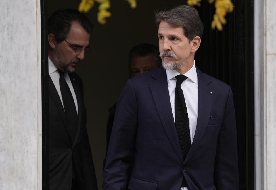 The sons of former King Constantine of Greece, Pavlos, right, and Nikolaos leave Maximos mansion, the prime minister's office, in Athens, Greece, Wednesday, Jan. 11, 2023. Greece's government says Constantine, the former and last king of Greece, will be buried as a private citizen in Tatoi, the former summer residence of Greece's royals where his parents and ancestors are buried. A controversial figure in Greek history, Constantine died in hospital late Tuesday at the age of 82. (AP Photo/Thanassis Stavrakis)