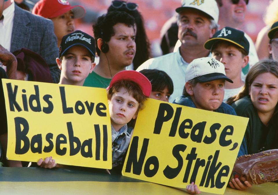 General view of young baseball fans holding up signs protesting against the proposed strike by the Major League Baseball Players Association during the Major League Baseball American League West game between the Oakland Athletics and the Seattle Mariners on 11th August 1994 at the Oakland-Alameda County Coliseum in Oakland, California, United States.