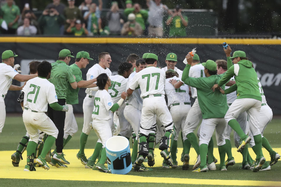 Oregon players celebrate after their win over Oral Roberts in an NCAA college baseball tournament super regional game Friday, June 9, 2023, in Eugene, Ore. (AP Photo/Amanda Loman)