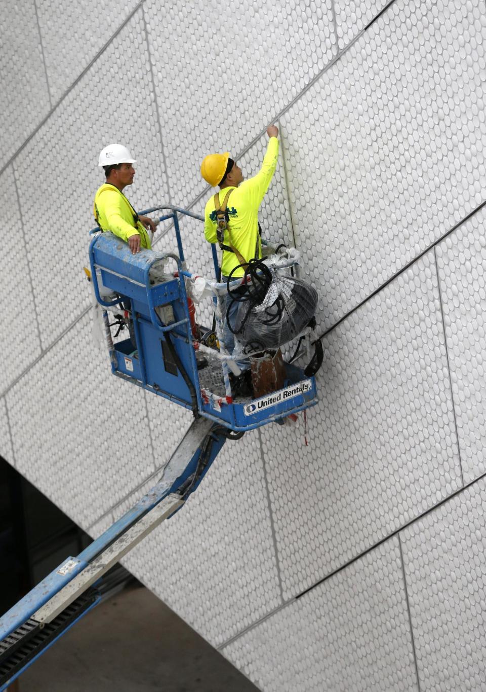 In this Thursday, Dec. 8, 2016 photo, workers are seen during construction at the Patricia and Phillip Frost Museum of Science in Miami. Rising next to Miami's spiffy new bayside art museum is a $305 million science museum that, like South Florida, is focused in large part on water: its centerpiece is a 500,000-gallon aquarium that will feature sharks, tuna, mahi-mahi and even sea turtles, with other smaller tanks for corals and other sea life. The Frost Science Museum, scheduled to open this spring. (AP Photo/Wilfredo Lee)