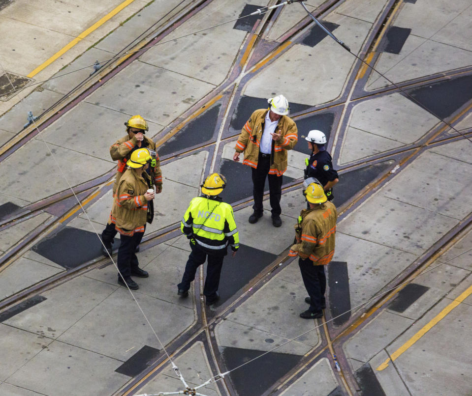 Firemen walk on Canal street in a barricaded area by the Hard Rock Hotel construction site in New Orleans, Friday, Oct. 18, 2019. The Hard Rock Hotel partially collapsed last week. (Sophia Germer/The Advocate via AP)/