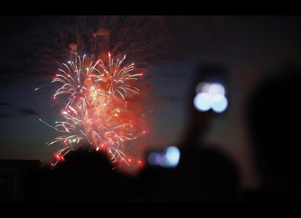 NEW YORK, NY - JULY 04:  Revelers take photos at XVI lounge as fireworks explode over the Hudson River on July 4, 2011 in New York City. The United States celebrated its 235th anniversary of declaring independence from the British Empire. (Photo by Mario Tama/Getty Images)