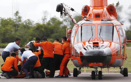 Indonesian Search and Rescue crews unload one of two bodies of AirAsia passengers recovered from the sea at the airport in Pangkalan Bun, central Kalimantan December 31, 2014. REUTERS/Darren Whiteside