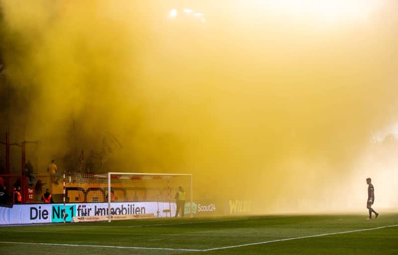 Borussia Dortmund fans set off pyrotechnics in the stadium's visitors' block during the German Bundesliga soccer match between 1. FC Union Berlin and Borussia Dortmund at Stadium An der Alten Foersterei. The match is interrupted due to the yellow smoke. Andreas Gora/dpa