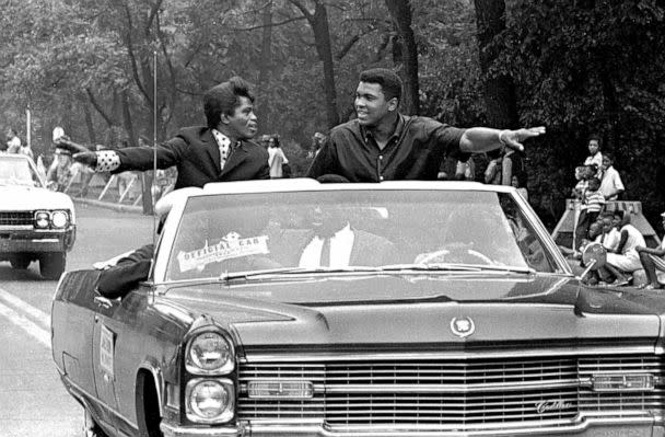 PHOTO: Singer James Brown and boxing champ Muhammad Ali smile and greet parade-goers while participating in the annual Bud Billiken parade, in Chicago, Aug. 1966.  (Robert Abbott Sengstacke/Getty Images)