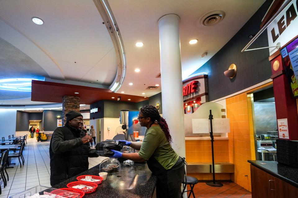 Trecia Leachmon hands a to-go order to a customer at Leachmon's Pit Stop BBQ in Valley West Mall.