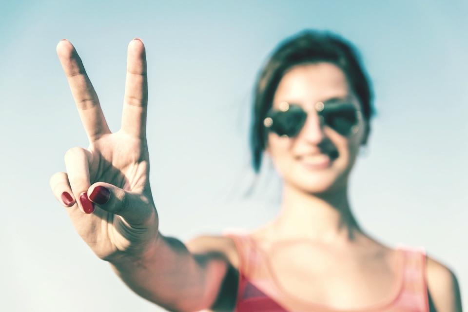 young woman giving peace sign