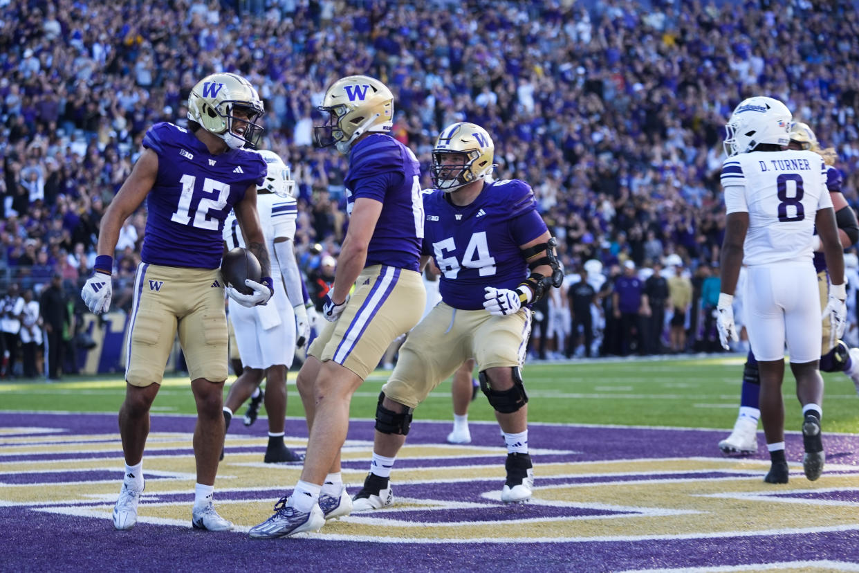 Washington wide receiver Denzel Boston (12) celebrates his touchdown with tight end Decker DeGraaf, front right, during the first half of an NCAA college football game against Northwestern, Saturday, Sept. 21, 2024, in Seattle. (AP Photo/Lindsey Wasson)