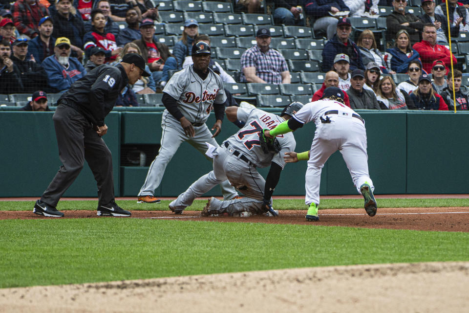 Detroit Tigers' Andy Ibanez (77) is safe at third base as Cleveland Guardians' Jose Ramirez, right, is late with the tag as Tigers third base coach Gary Jones, second from left, and umpire Vic Carapazza, left, watch during the third inning of a baseball game in Cleveland, Monday, May 8, 2023. (AP Photo/Phil Long)