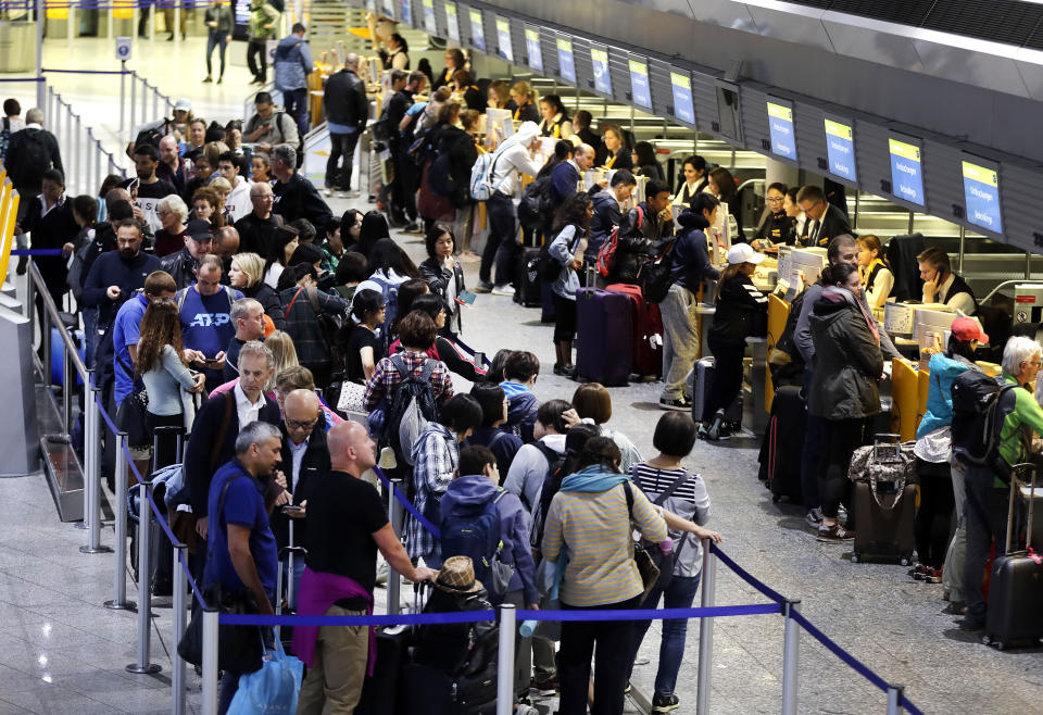 Passengers queue in a terminal at the airport in Frankfurt, Germany, Thursday, Nov. 7, 2019. The flight attendants' union Ufo is on strike at Lufthansa for 48 hours. (AP Photo/Michael Probst)