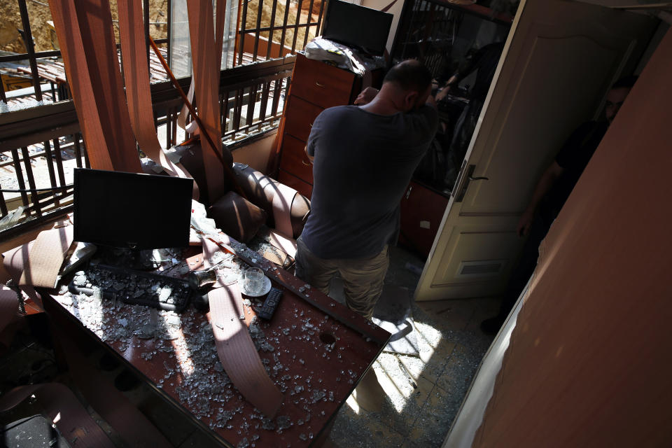 A man stands inside a damaged media office in a stronghold of the Lebanese Hezbollah group, in a southern suburb of Beirut, Lebanon, Sunday, Aug. 25, 2019. Two Israeli drones crashed in a Hezbollah stronghold in the Lebanese capital overnight without the militants firing on them, a spokesman for the group said Sunday, saying the first fell on the roof of a building housing Hezbollah's media office while the second landed in a plot behind it. (AP Photo/Bilal Hussein)