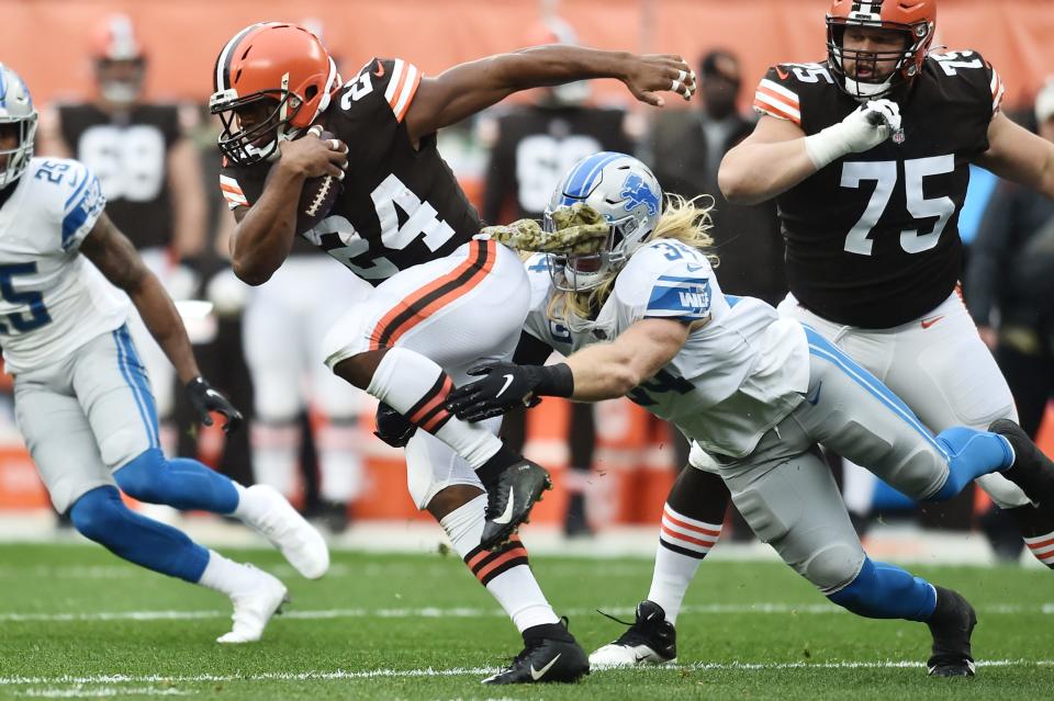 Cleveland Browns running back Nick Chubb runs with the ball as Detroit Lions inside linebacker Alex Anzalone goes for the tackle during the first half at FirstEnergy Stadium, Nov. 21, 2021.