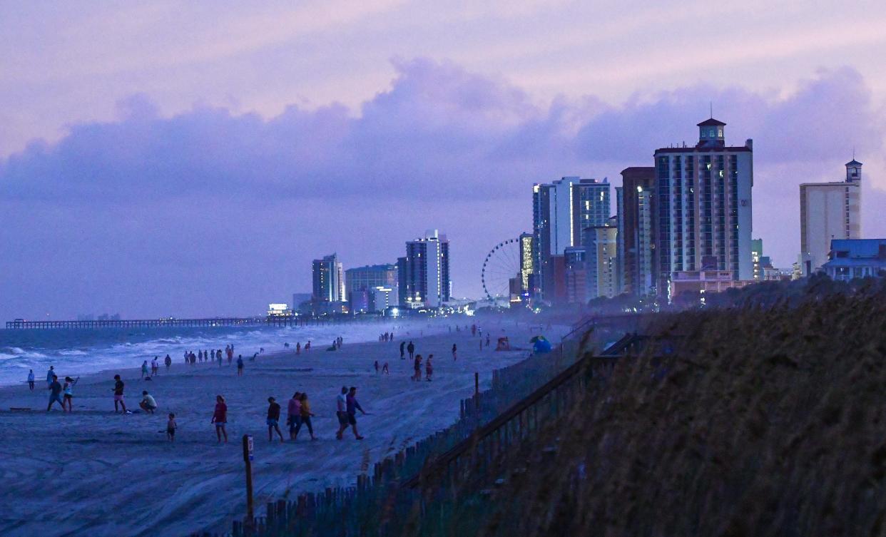 People walk and play along the shoreline near evacuated hotels along North Ocean Boulevard in Myrtle Beach, South Carolina Tuesday, Sept 3, 2019 when the Hurricane Dorian dawned.