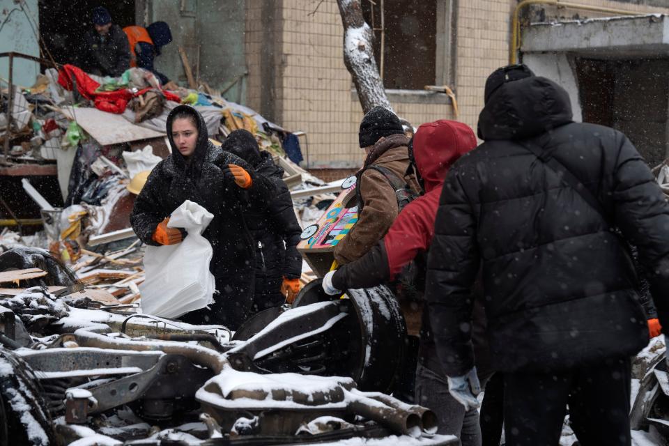 Survivors of a Russian missile attack in Kyiv, Ukraine, gather belongings amid the debris of their destroyed home on Jan. 3, 2024.