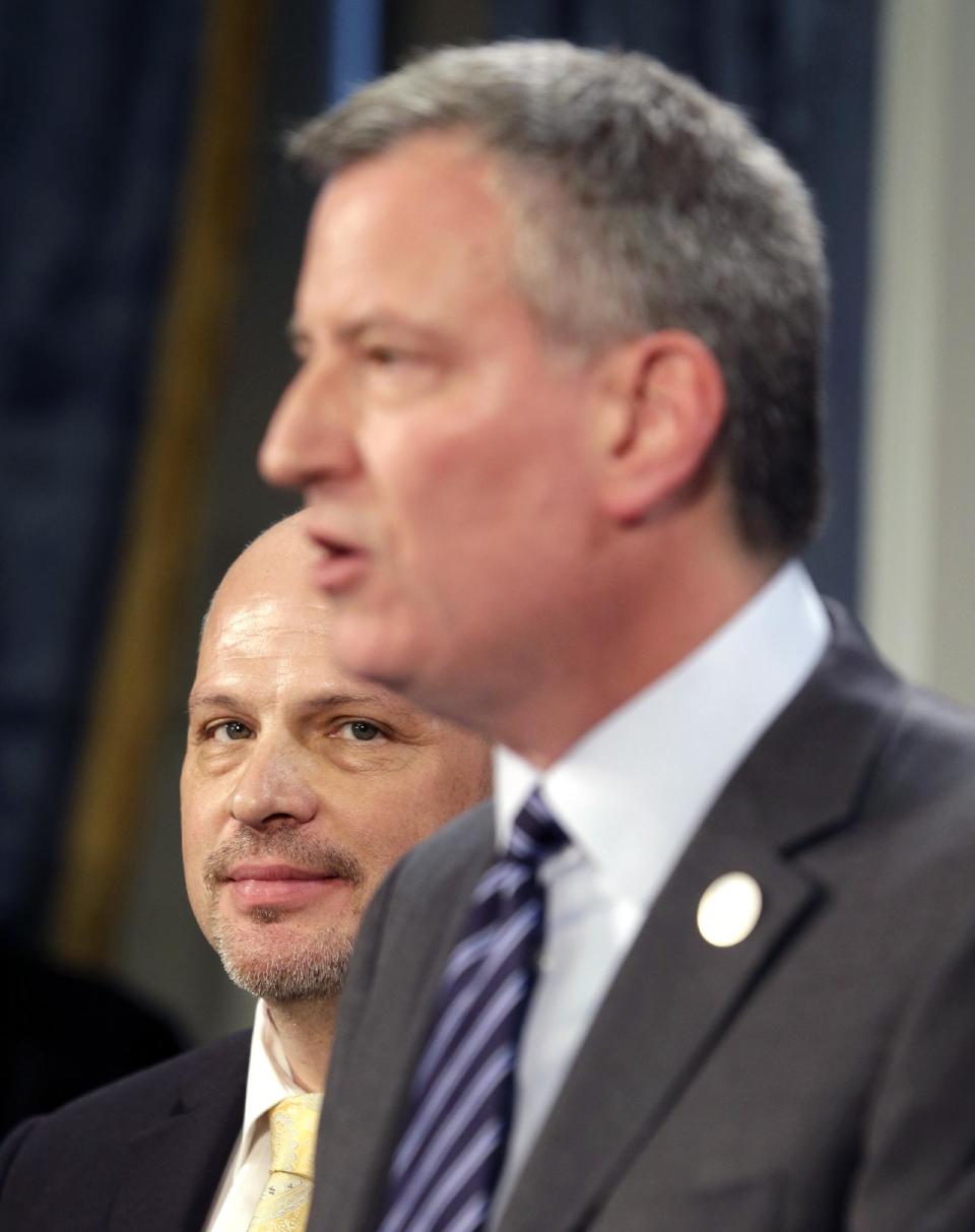 President of the United Federation of Teachers Michael Mulgrew, left, looks on as New York City Mayor Bill de Blasio speaks during a news conference at City Hall in New York, Thursday, May 1, 2014. New York City and its largest teachers union struck a deal on a new contract Thursday, ending a nearly five-year labor dispute and potentially setting a template for negotiations with the city's other unions. (AP Photo/Seth Wenig)