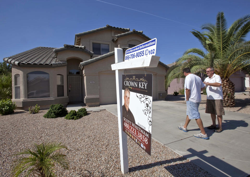 Re/Max Solutions Associate Broker Kurt Sabel, right, talks with prospective buyer Ned Pierce outside a home for sale in Gilbert, Ariz.(Credit: Matt York, AP Photo)