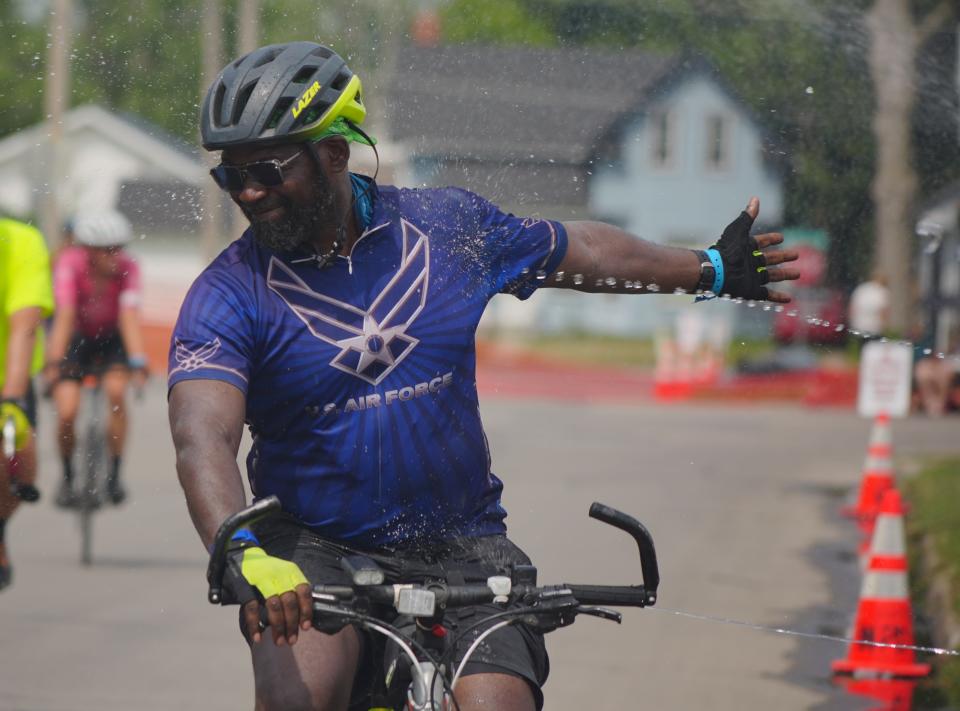 Riders get sprayed with water as they roll into Newton as RAGBRAI 50 rolls toward Tama-Toledo on Day 5 of the ride on Thursday, July 27, 2023.