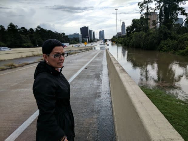 Rosanna Moreno looks over the flooded Buffalo Bayou on Interstate 610. (Photo: Roque Planas/HuffPost)