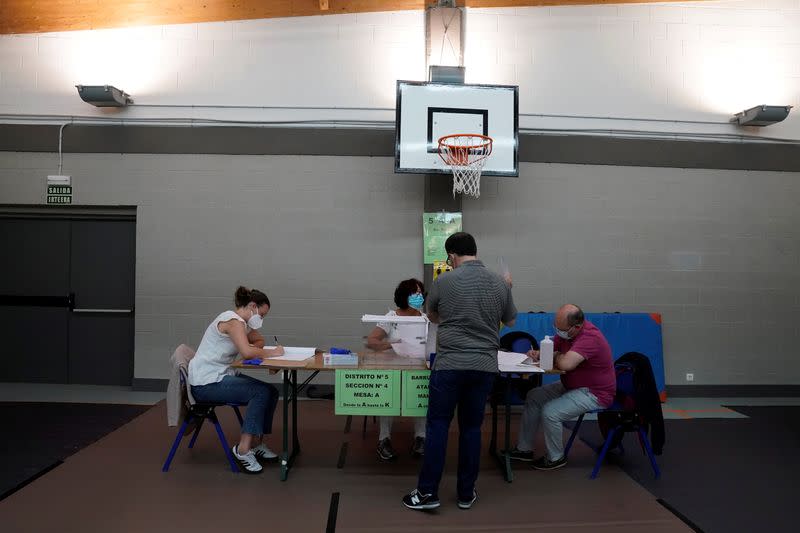 Workers organize papers at a polling station before the start of the voting during the Basque regional elections, amid the coronavirus disease (COVID-19) outbreak, in Durango